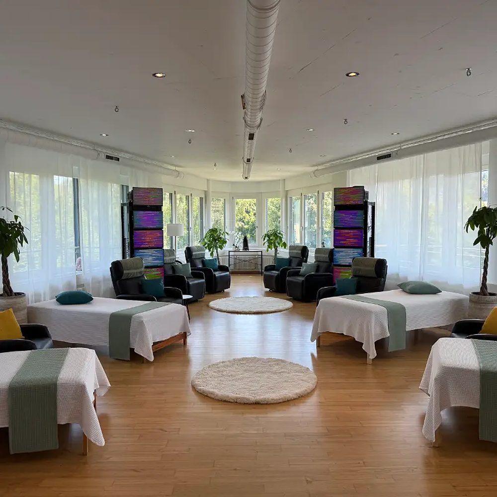 Blick in den hellen Raum mit Betten und Relaxsesseln.